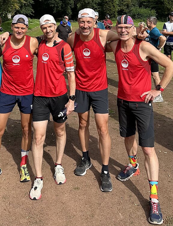 Gruppenfoto: Unser Mitarbeiter Matthias mit drei Freunden, alle tragen Laufkleidung