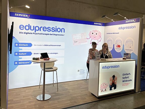 Bild des edupression Messestandes mit zwei Mitarbeiterinnen der Firma Servier.